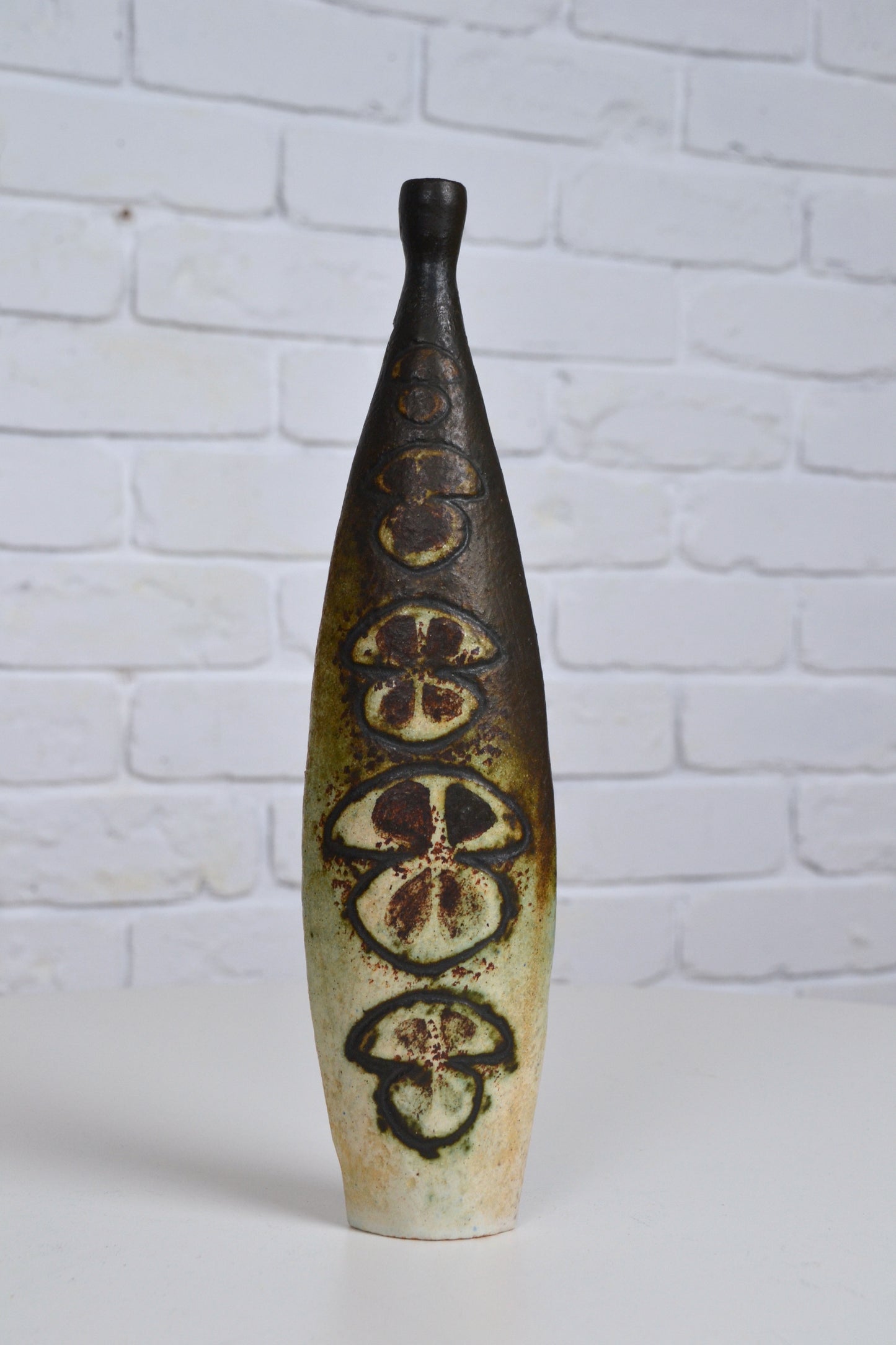 A mid-century ceramic vase with patterned details, predominantly brown in color, signed with an 'W'.